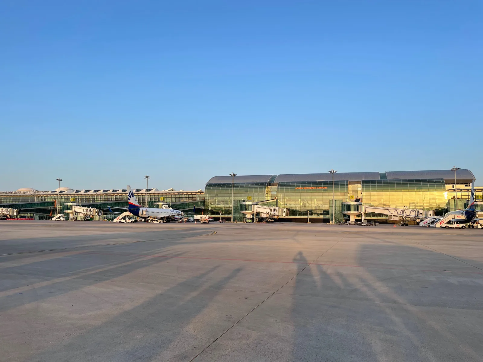 İzmir Adnan Menderes Airport international terminal seen from the apron with aircraft stands.